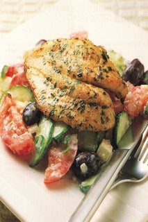 Grilled fish fillets on Greek salad